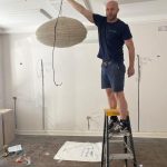 a man holding a chandelier on a ladder